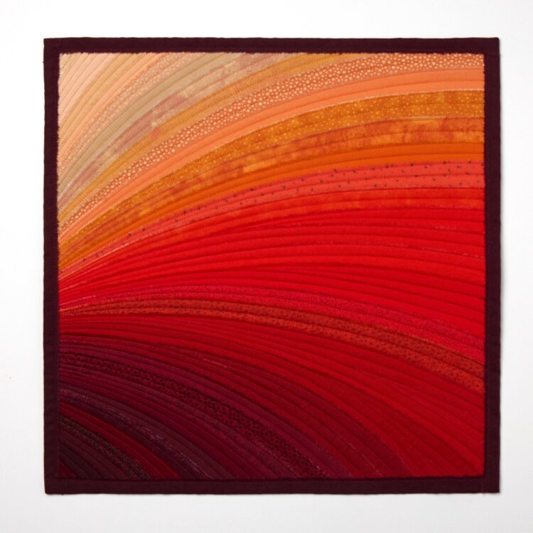 image of quilt artwork containing a colour gradient patter of oranges and reds. 