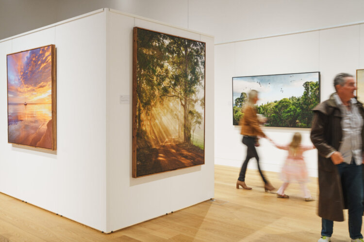 People looking at landscape photography in an art gallery
